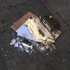 a broken mirror sitting on the ground next to a building