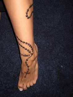 a person with a rosary tattoo on their foot