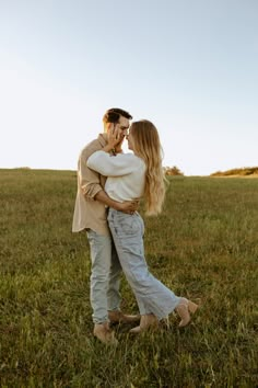 a man and woman embracing in the middle of a field