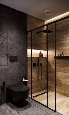 a bathroom with a black toilet and wooden walls, along with a walk in shower