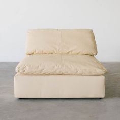 a white couch sitting on top of a cement floor