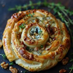 some kind of pastry with nuts and herbs on top