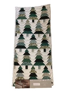 a quilted christmas tree with green and white trees on the front, along with a tag