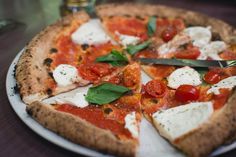 two different views of a pizza with tomatoes and mozzarella toppings on it