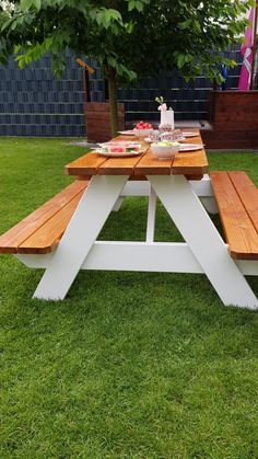 a picnic table with two benches in the grass