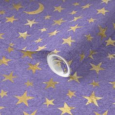 purple and gold stars wallpaper with metallic foil on the bottom, along with a roll of tape