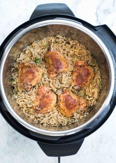 chicken and rice in an instant pot on a marble counter top with a black lid