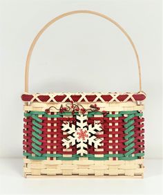 a woven basket with a snowflake design on the front and sides, sitting on a white surface