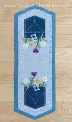 a blue and white banner with flowers in it on a wooden floor next to wood planks