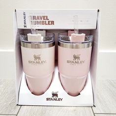 two pink tumblers sitting inside of a box on the floor next to each other