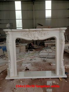 a white fireplace in a room with lots of debris