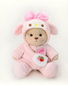 a pink teddy bear with a bow on it's head, sitting in front of a white background