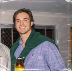 two men standing next to each other holding bottles