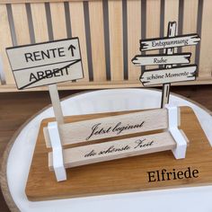 two wooden signs sitting on top of a white table next to a wood sign that says rente albert