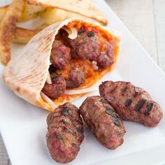 some meatballs and pita bread on a white plate