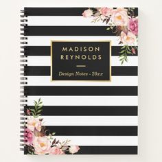 a black and white striped notebook with pink flowers on the cover, next to a pen