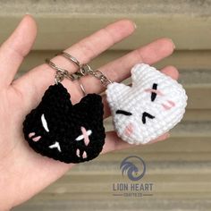 two crocheted keychains with cats on them in the palm of someone's hand