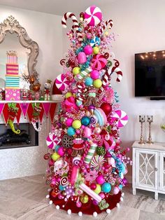 a brightly colored christmas tree with candy and lollipops