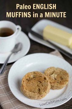 two muffins on a white plate next to a cup of coffee and butter