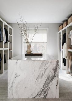 a white marble counter top in a walk - in closet