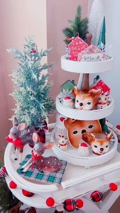 three tiered christmas tree with deer figurines on top and other holiday decorations