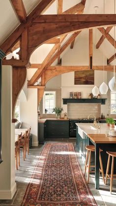 an open kitchen and dining area with wooden beams