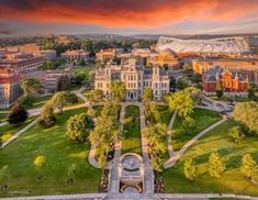 an aerial view of the university campus and surrounding buildings at sunset, with red clouds in the sky