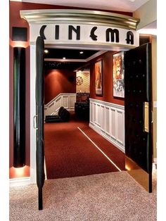 an open door leading to a movie room with red carpeting and white trimming