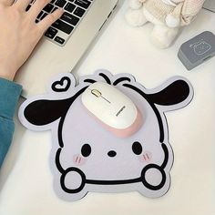 a mouse pad with a cartoon character on it next to a laptop and a teddy bear