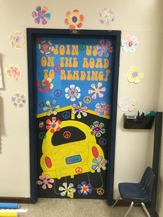 a classroom door decorated with flowers, peace signs and a school bus painted on it