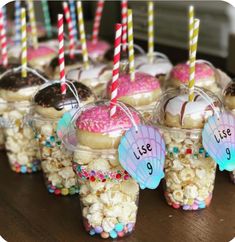 cupcakes and candy are arranged in little cups with straws on them for a birthday party