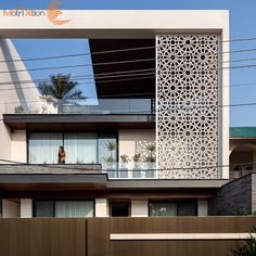 a tall white building sitting next to a wooden fence