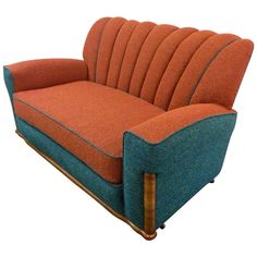 an orange and blue couch sitting on top of a wooden frame