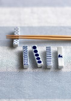 chopsticks and erasers sitting on top of a blue table cloth next to some chopsticks