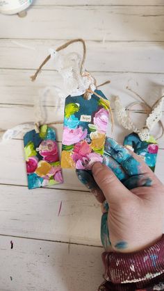 someone is painting flowers on small tags with acrylic paint and twine of twine