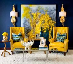 a living room with two yellow chairs and a coffee table in front of a painting