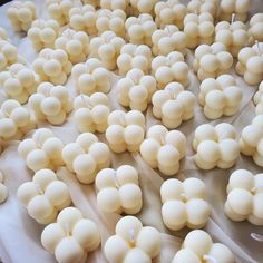 many small white candles are on a sheet of wax paper and ready to be lit