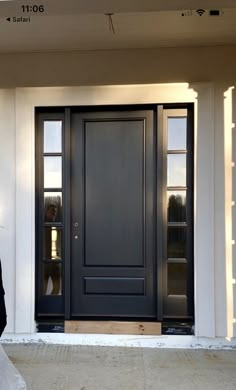 a bride and groom standing in front of a black door