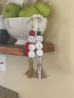 some apples are sitting in a bowl on a shelf