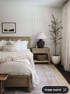 a bedroom with white walls and wooden furniture