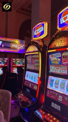 several slot machines in a casino with neon lights