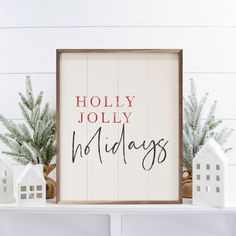 there is a sign that says holidays on the shelf next to some small white houses