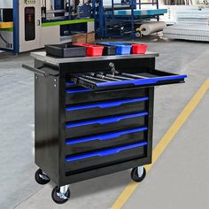 a toolbox with blue drawers on wheels in a factory