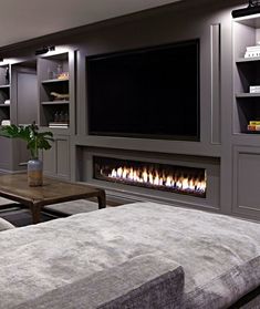 a living room filled with furniture and a flat screen tv mounted on the wall above a fire place