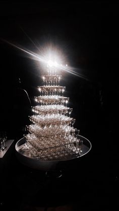 a very tall cake sitting on top of a white plate covered in lots of wine glasses