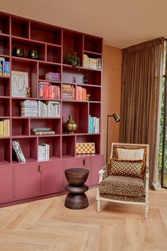 a living room filled with lots of bookshelves next to a chair and table