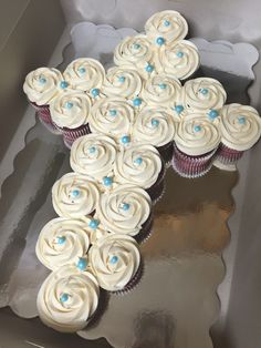 cupcakes with white frosting and blue sprinkles in a box