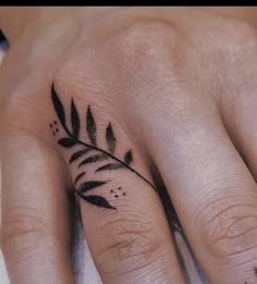 a black and white photo of a hand with a tattoo on it's fingers