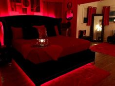 a bedroom with red lighting and black furniture