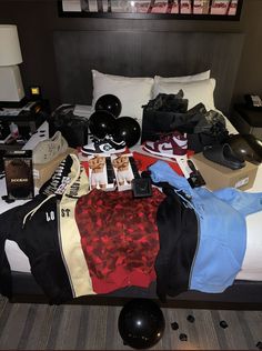 an unmade bed with clothes and shoes on it in a hotel room at night